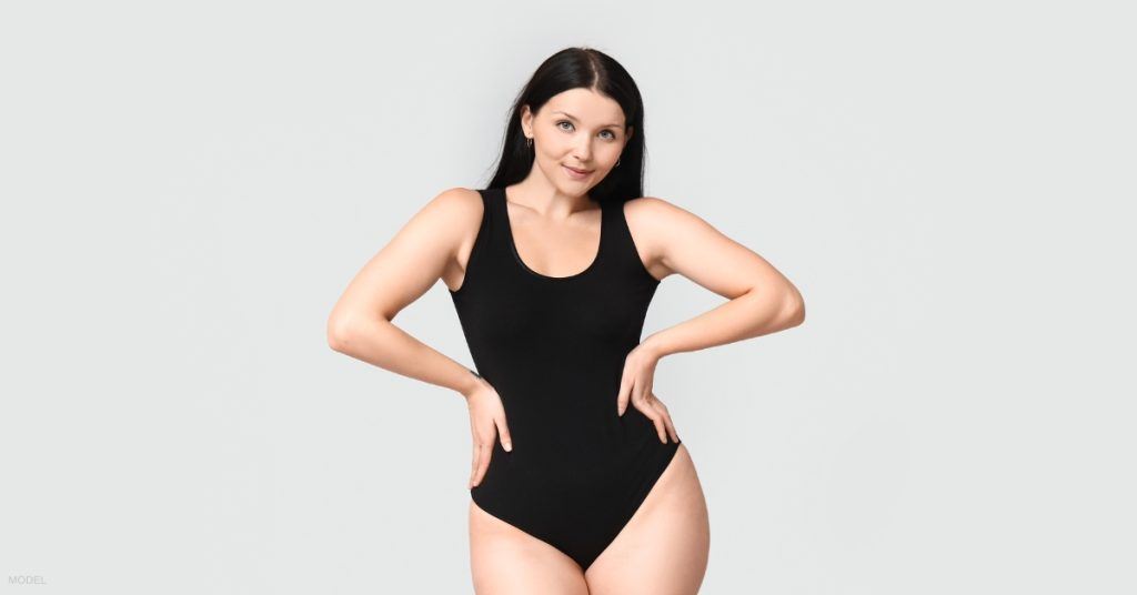 Beautiful woman in black bodysuit (MODEL) enjoying her liposuction results.